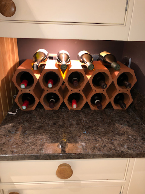 Wine racks on kitchen counter under cabinet lighting